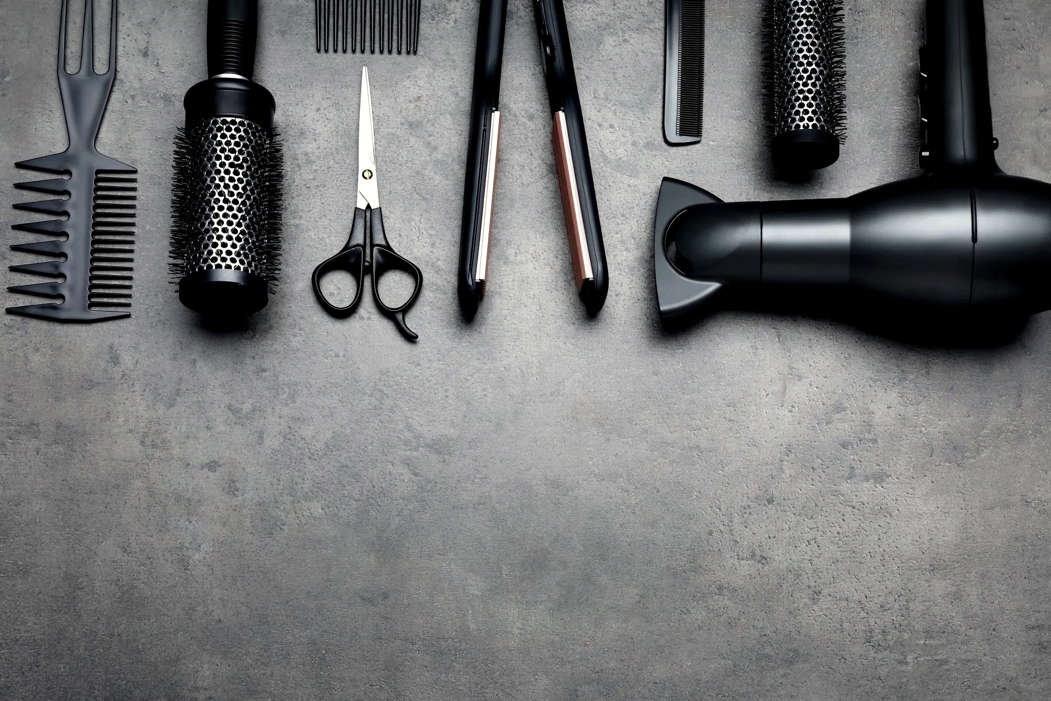 Professional hair styling tools flat lay dark background